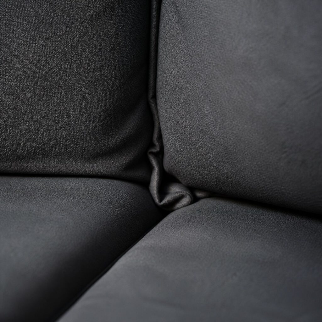 Gros plan sur la couture d'angle et le surplus de tissu rentré entre assise et dossier