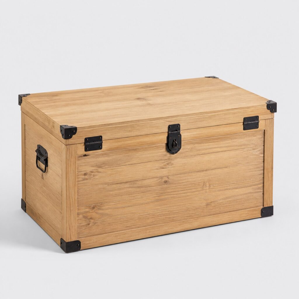 Malle de rangement en bois clair à ferrures noires sur fond neutre