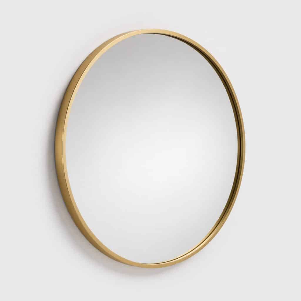 Miroir mural rond à cadre doré fin sur fond gris clair