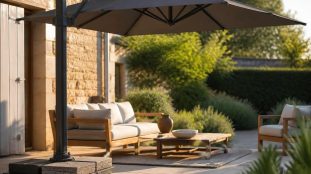 Parasol déporté ouvert sur une terrasse, avec sa base en croix chargée de dalles de lestage carrées empilées